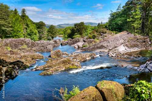 Scenic landscape with blue water which streams through rocky rapids near Ring of Kerry Ireland