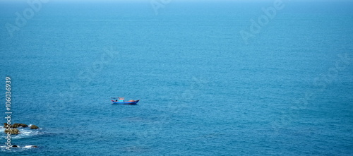 Far way small lonely boat in the blue sea. Landscape of Eo Gio cape, Binh Dinh province, Vietnam. © umitory