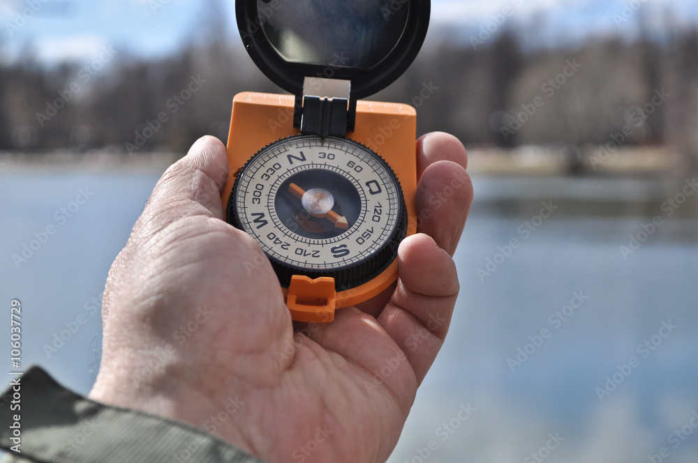 The compass in his hand outdoors. The compass in his hand outdoors.