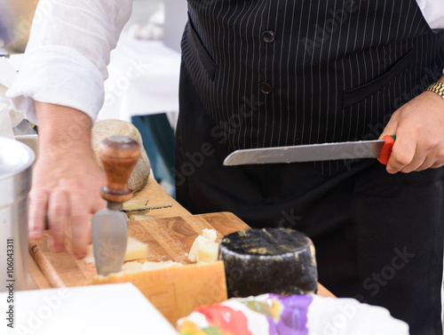 Cameriere taglia il formaggio parmigiano, fuoco selettivo