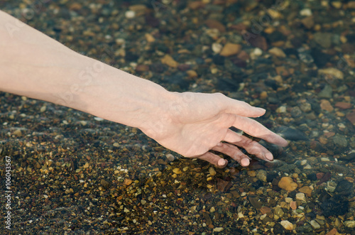 River water theme: the human hand touches the water in the river © Parad St