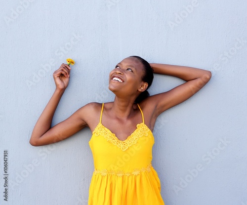 Young african woman in yellow dress a flower