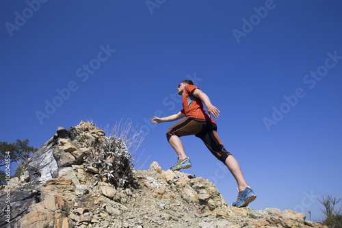 Trail running athlete man training for fitness and marathon living healthy lifestyle outside in beautiful landscape on Big Island.