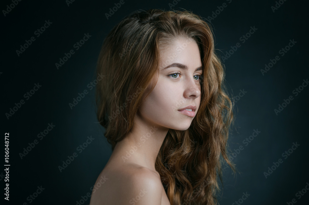 Dramatic portrait of a girl theme: portrait of a beautiful girl with flying hair in the wind against a background in studio Dramatic portrait of a girl theme: portrait of a beautiful girl with flying hair in the wind against a background in studio