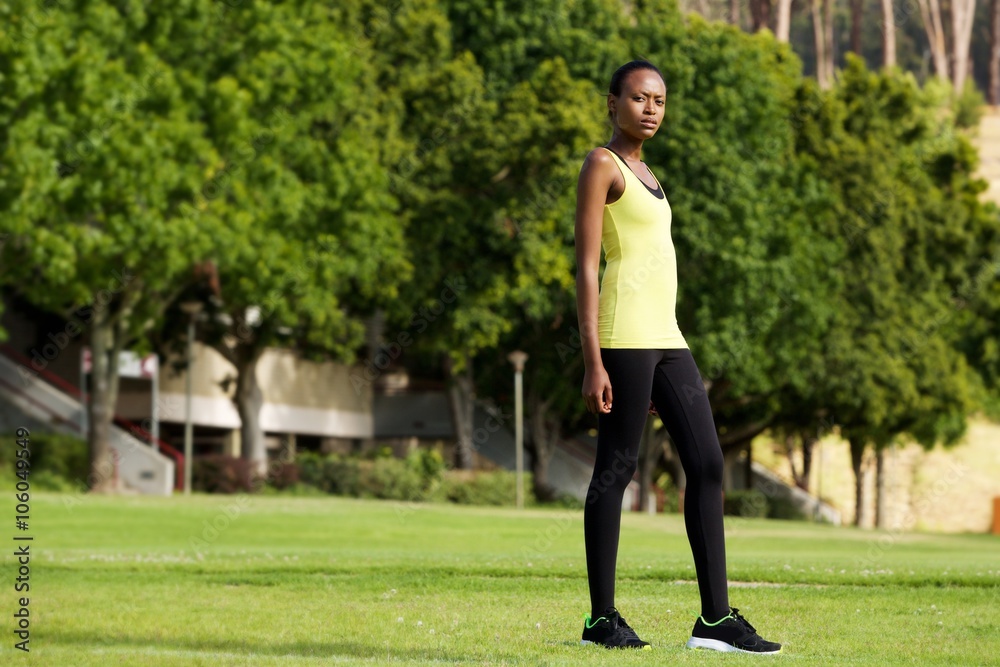 Fit young woman in sportswear standing in a park Fit young woman in sportswear standing in a park