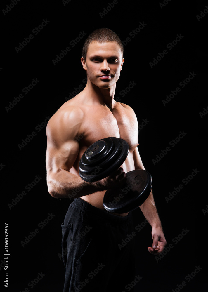 Strong, fit and sporty bodybuilder man with a dumbbell