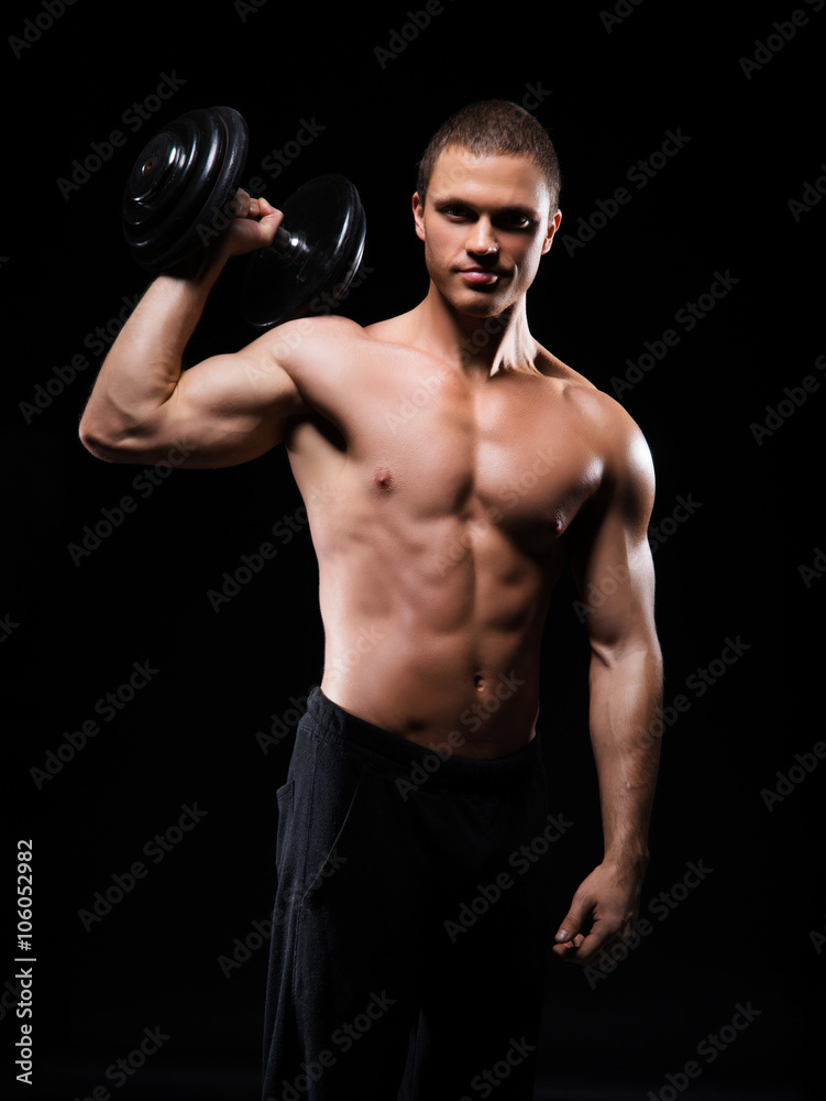 Strong, fit and sporty bodybuilder man with a dumbbell