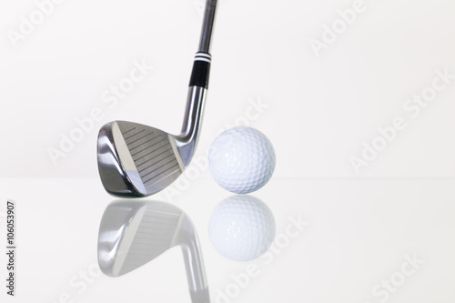 Golf club and golf ball on the glass desk