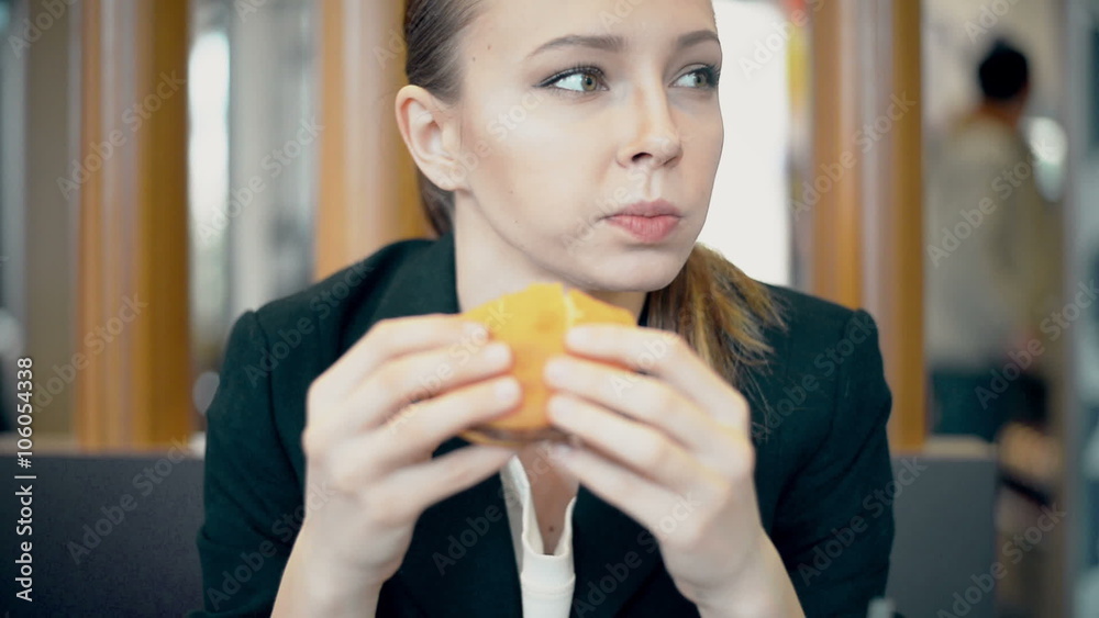 Woman eating burger and fries smiling. Beautiful mixed race female model Woman eating burger and fries smiling. Beautiful mixed race female model