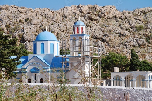 The domed church at Emborio cemetery on the Greek island of Halki. The damaged bell tower is supported by scaffold. photo