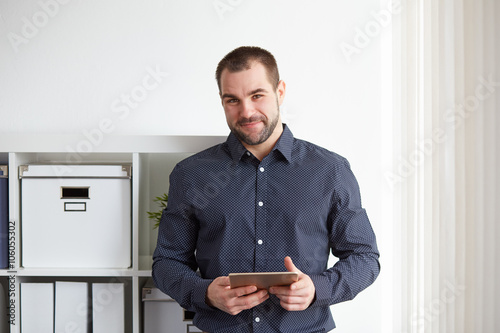 Man in office with tablet photo