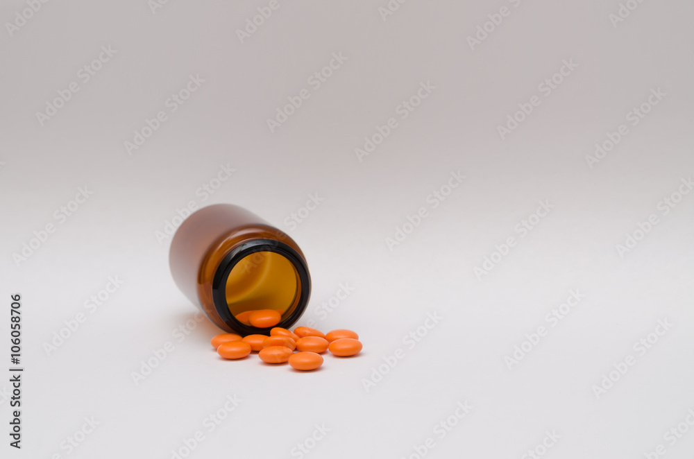 Orange pills scattered on a table