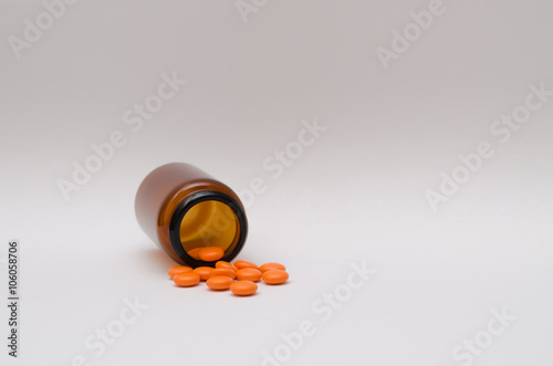 Obraz na płótnie Orange pills scattered on a table w salonie