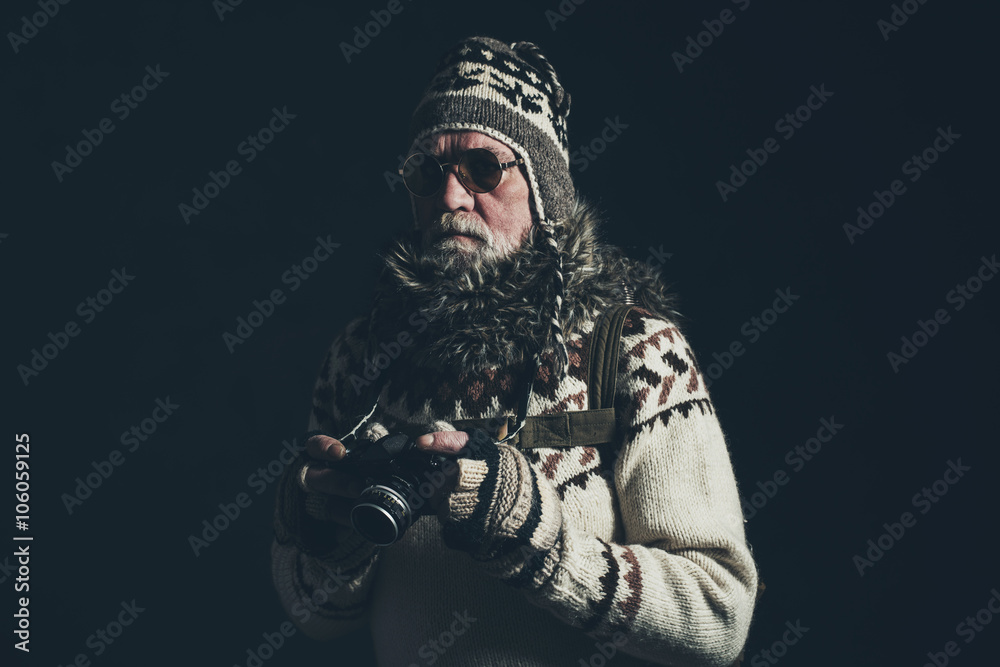 Vintage senior mountaineer holding SLR camera wearing knitted sw