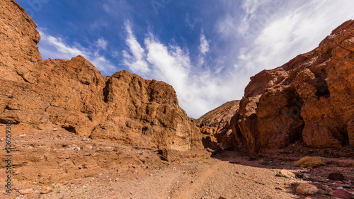 Narrow canyon with vertical walls on both sides. Rocky landscape background. Natural bridge canyon trail  Death Valley