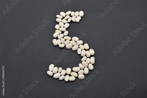 Number five made from white beans on black background. Food vega