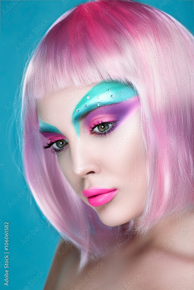 Beautiful face of puppet girl with face art in pink wig on serenity background Beautiful face of puppet girl with face art in pink wig on serenity background
