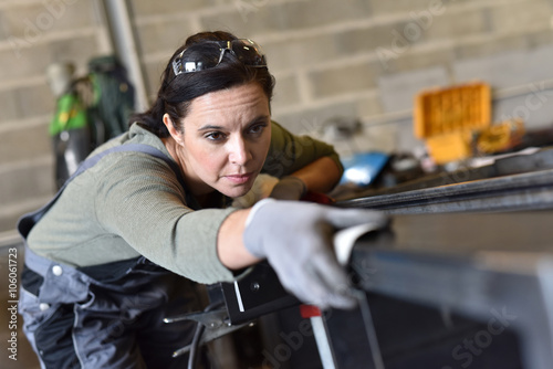 Slika na platnu Metalworker sanding down piece of metal