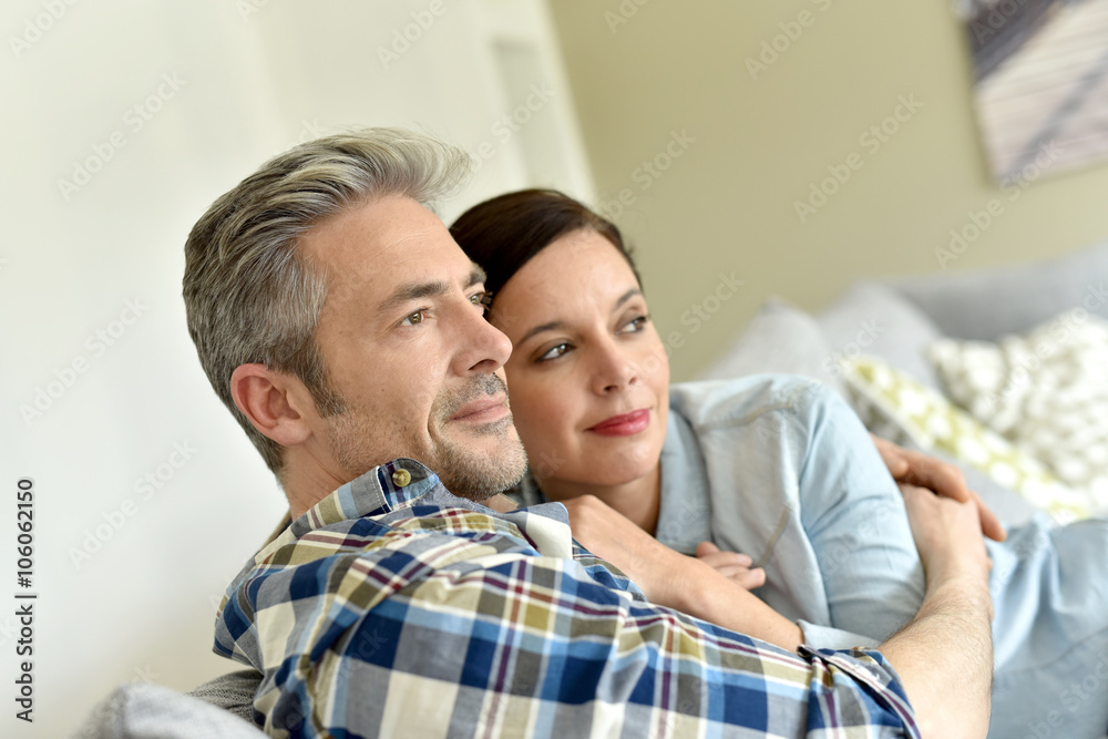 Middle-aged couple relaxing in sofa looking to the outside Middle-aged couple relaxing in sofa looking to the outside
