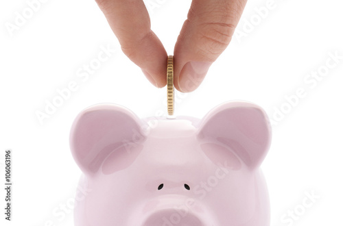 Putting coin into the piggy bank 