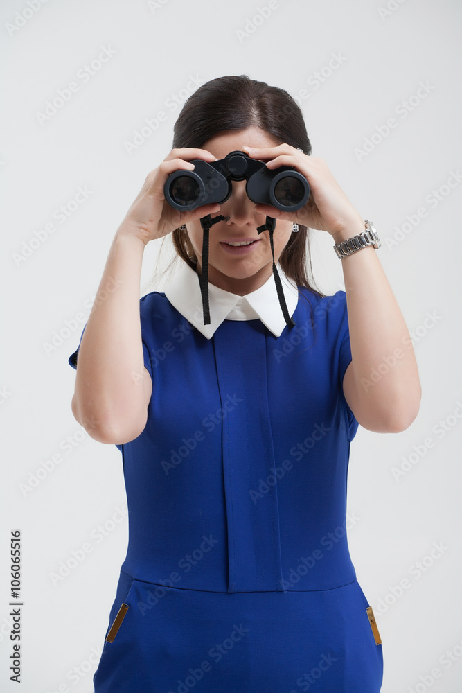 Girl in a blue suit. Keep a binoculars in his hands. Makes gestu Girl in a blue suit. Keep a binoculars in his hands. Makes gestu