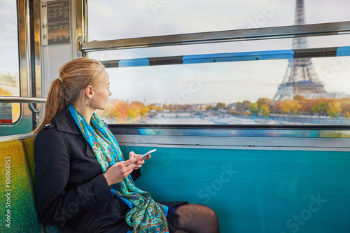 Photography Beautiful young woman travelling in a train of Parisian underground and using he