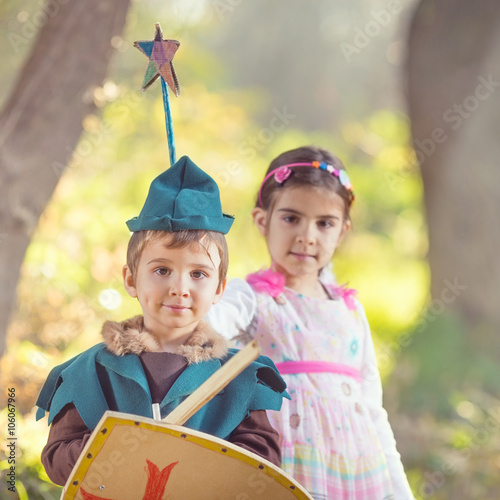 Cute little children dressed up as a fairy and a knight playing in a dreamlike nature
