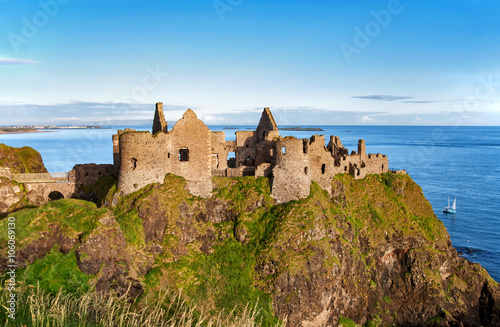 Ruins of Dunluce castle in County Antrim, Northern Ireland, UK, with the far view of Portrush resort on the left