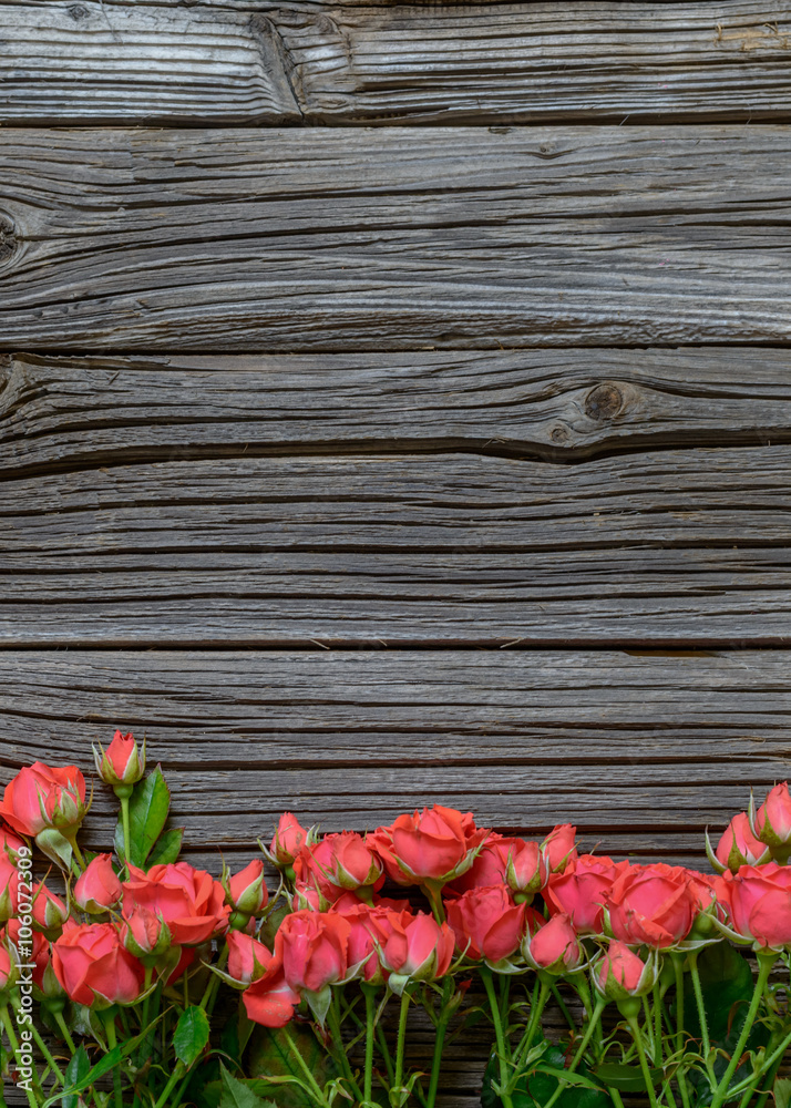 Fototapeta premium Top down view on rose bundle on wooden surface