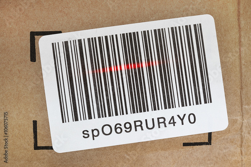 Barcode label on shipping box being scanned by laser scanner.