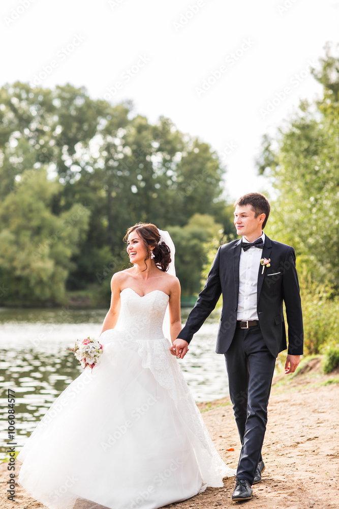 Wedding couple walking  near lake.