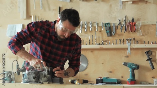 The carpenter planes the wood