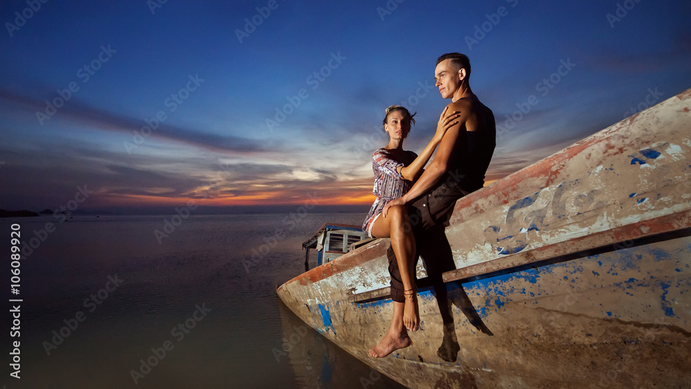 Young couple is sitting on the sunken ship