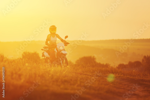 Woman biker in sunset  female motorcycle.