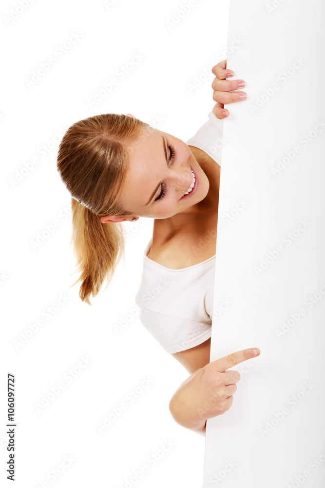 Smiling young woman pointing for empty banner Smiling young woman pointing for empty banner