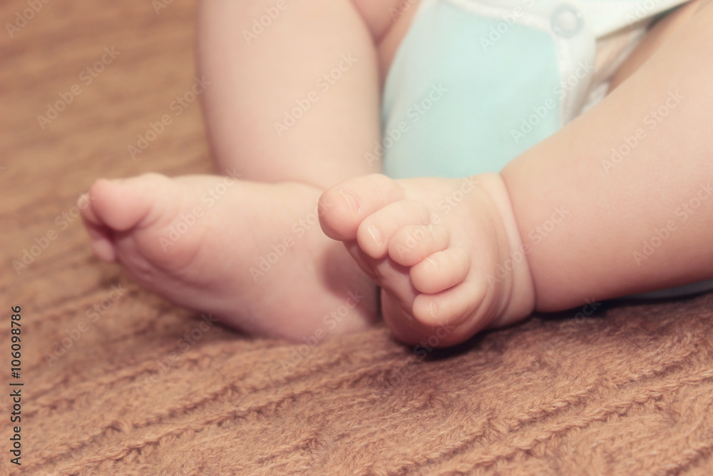 Newborn baby feet on knitted background, mother's day concept