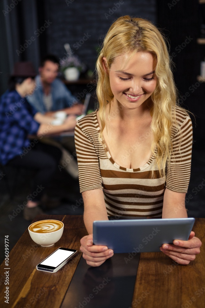 Woman drinking coffee and using tablet Woman drinking coffee and using tablet