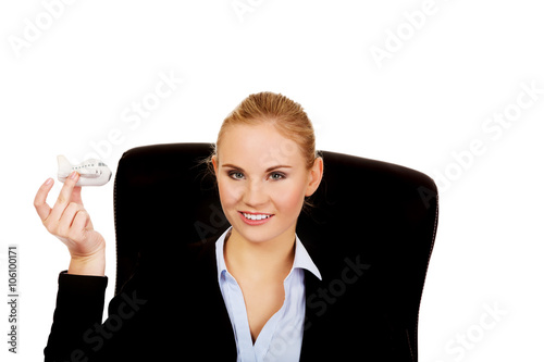 Business woman sitting on wheel chair and holding toy plane