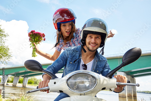 Cheerful couple riding vintage scooter