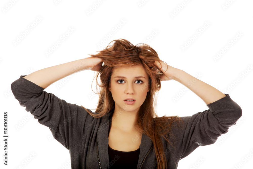 Young surprised woman holding hands inside hair Young surprised woman holding hands inside hair