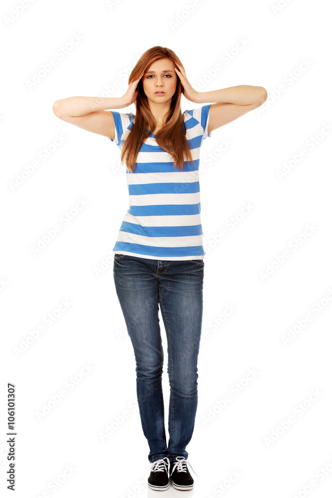 Teenage woman with headache holding her hand to the head Teenage woman with headache holding her hand to the head