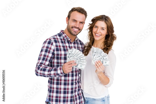 Happy young couple holding fanned out currency notes