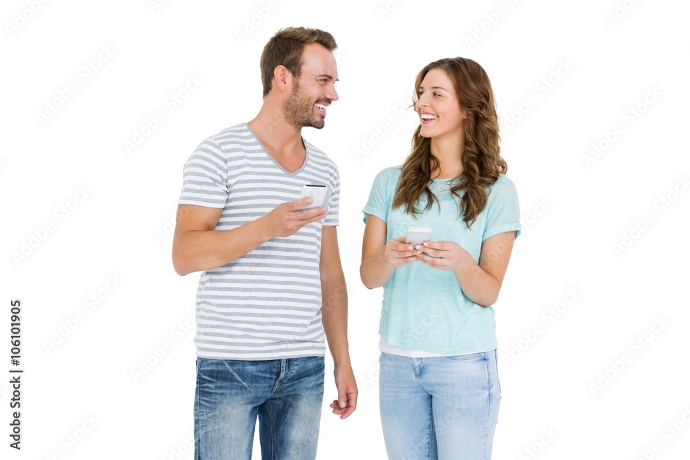 Happy young couple text messaging on mobile phone Happy young couple text messaging on mobile phone