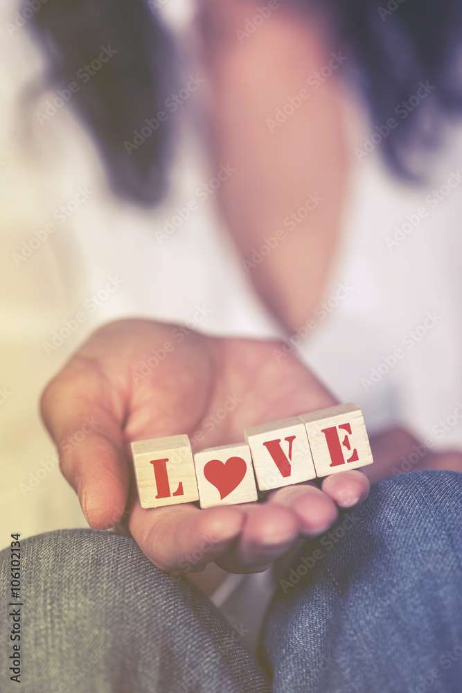 Hands holding Love message formed with wooden blocks Hands holding Love message formed with wooden blocks