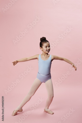Young girl ballet dancing in pink studio