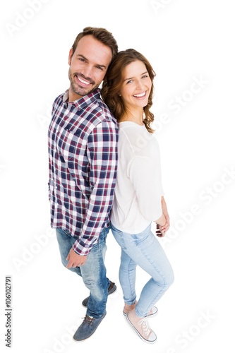 Happy young couple standing back to back