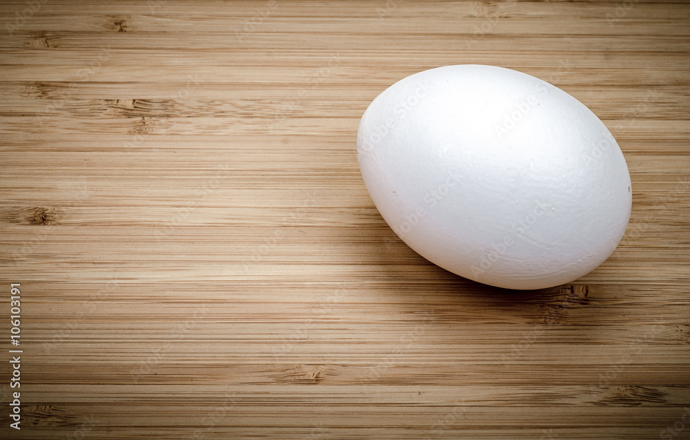 White one Egg on a wooden surface clous up White one Egg on a wooden surface clous up