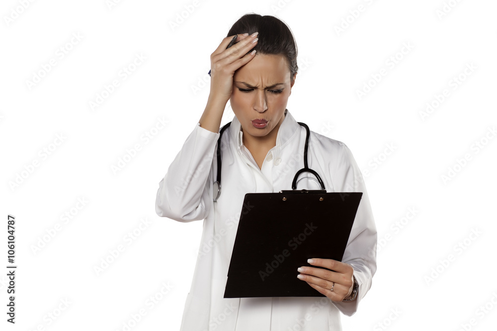 amazed woman doctor in uniform reading her clipboard amazed woman doctor in uniform reading her clipboard
