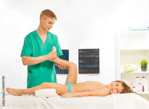 Smiling boy lying on the massage table photo