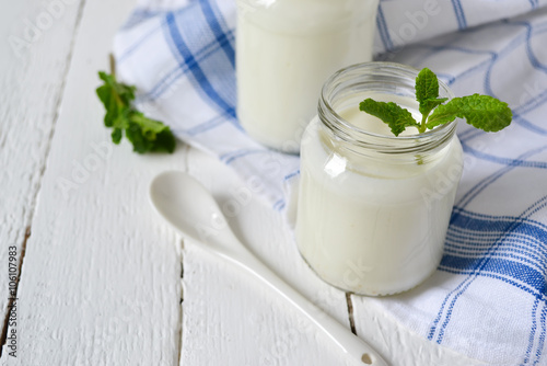 natural yogurt in glass jar, white background